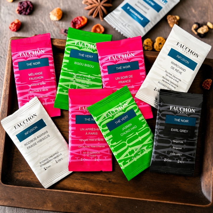 Assortiment lumineux de sachets de thé noir, thé vert et infusions sur un plateau en bois