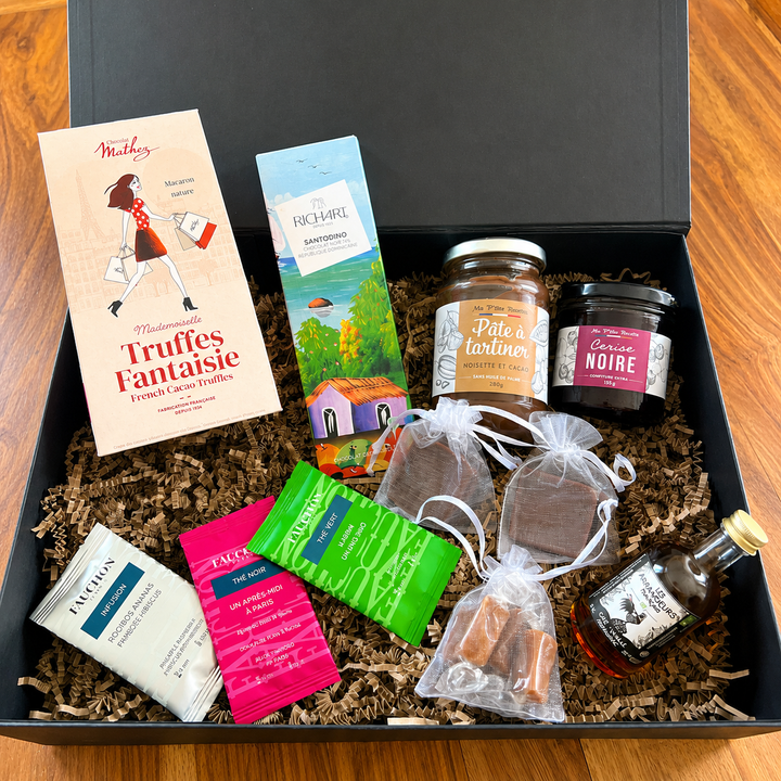 Box Signature Gourmande KLycia avec chocolat noir, pâte à tartiner, thés FAUCHON, armagnac, confiture, bonbons et truffes au chocolat.