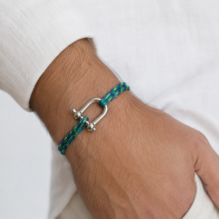 Bracelet en paracorde turquoise et jaune porté au poignet d’un homme