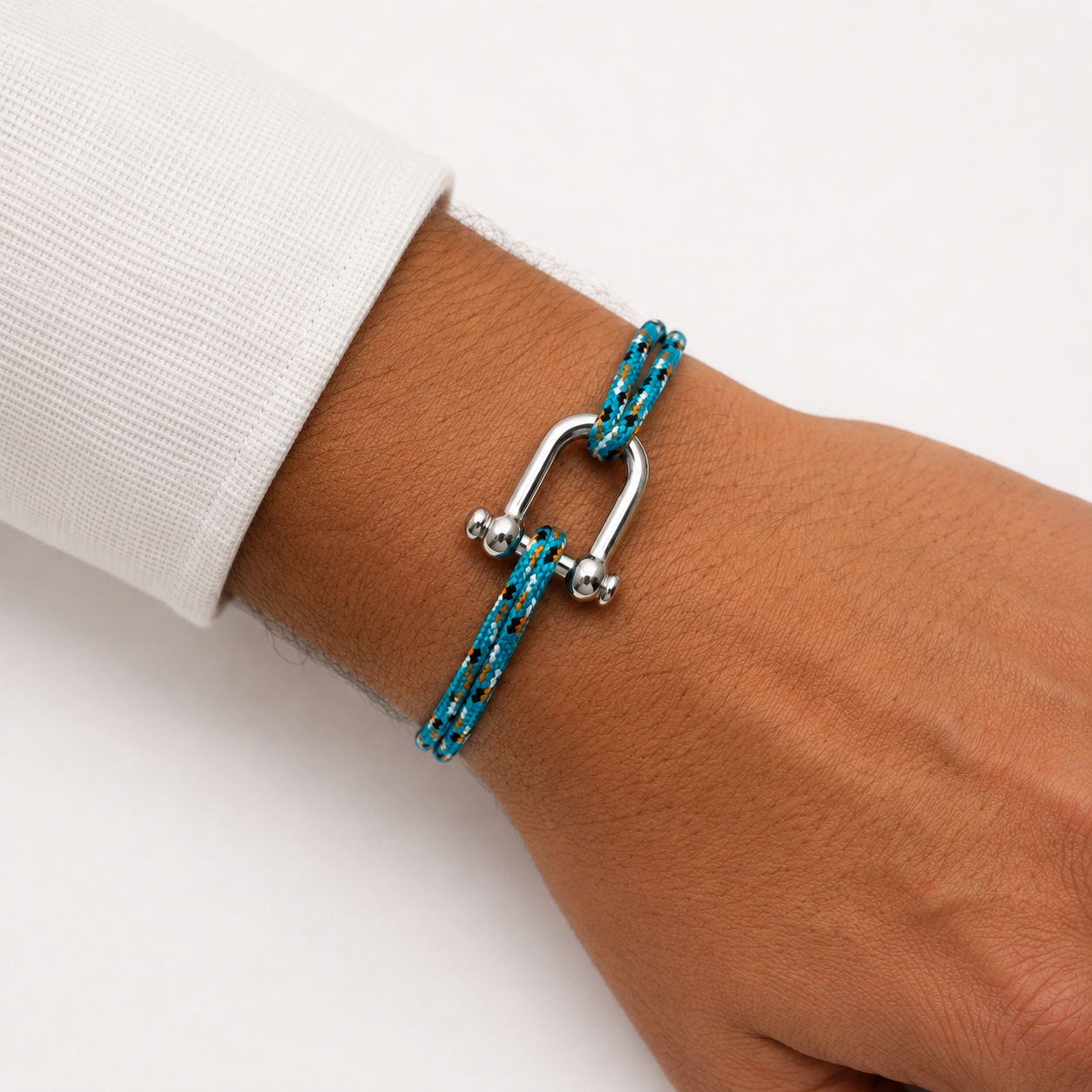 Bracelet en paracorde turquoise et orange porté au poignet d’un homme