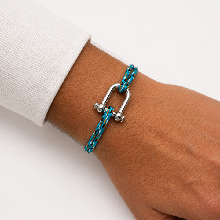 Bracelet en paracorde turquoise et orange porté au poignet d’un homme