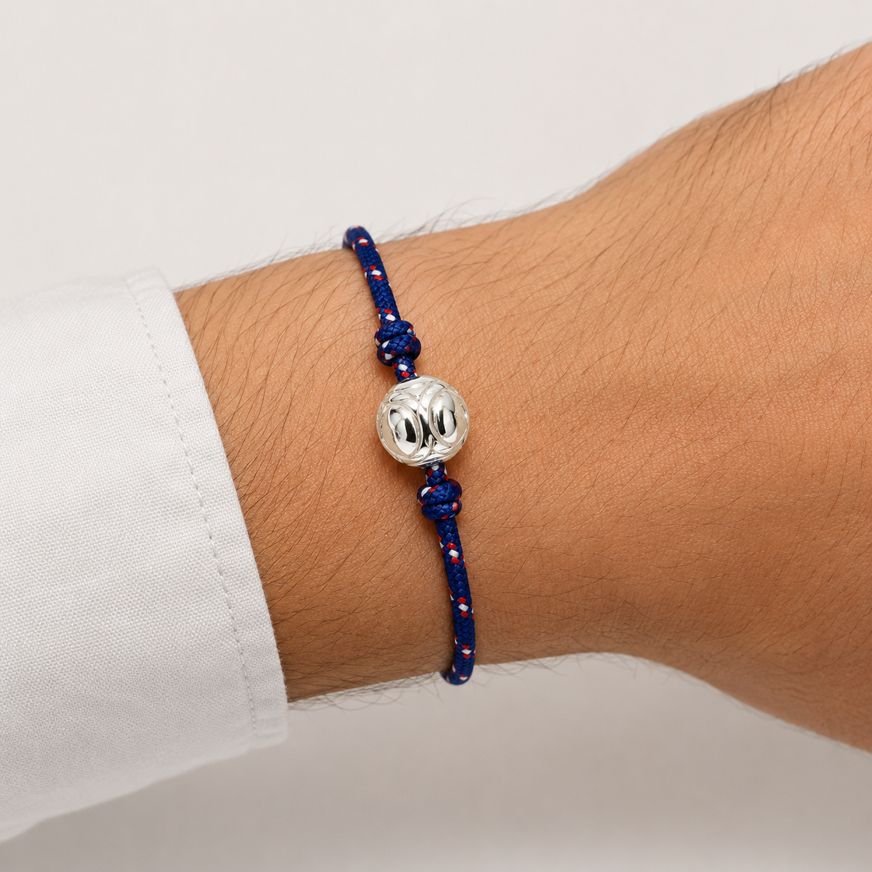 Bracelet pétanque avec boule argentée porté au poignet d’un homme