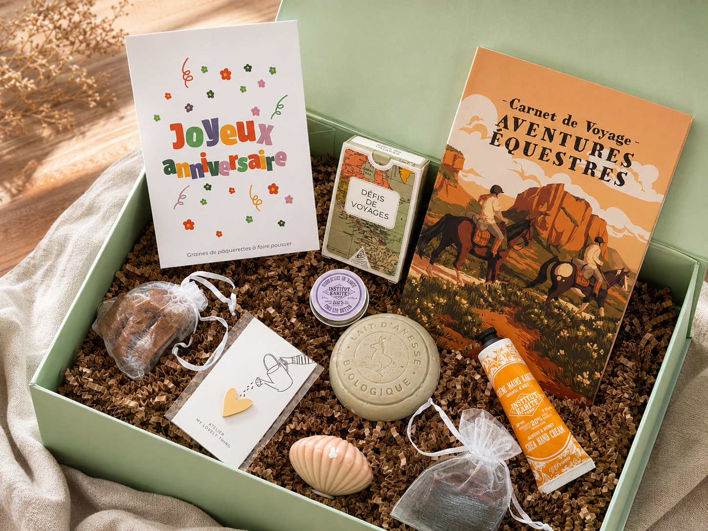 Coffret cadeau d’anniversaire à composer avec carnet de voyage, soins, accessoires et petites attentions dans une box verte.